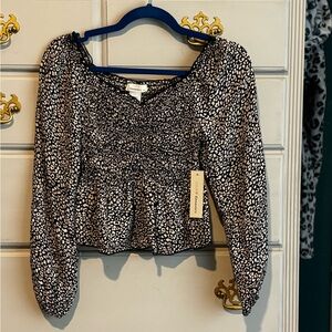 Black and white size S blouse.  Sits at hem of your pants.